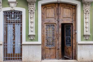 due porte in legno sul lato di un edificio di FLORIT FLATS - Traditional House in El Cabanyal a Valencia