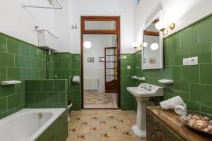 La salle de bains verte est pourvue d'une baignoire et d'un lavabo. dans l'établissement FLORIT FLATS - Traditional House in El Cabanyal, à Valence