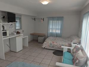 a small bedroom with a bed and a kitchen at Larochelle Guesthouse in Keetmanshoop
