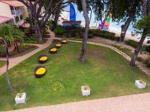 Tamarind by Elegant Hotels - All-Inclusive في سانت جيمس: مجموعة من الأطباق الطائرة على العشب في حديقة