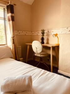 a bedroom with a bed and a desk with a chair at 'Melrose' at stayBOOM in Lancaster