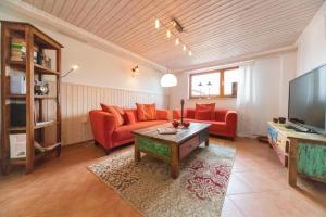 sala de estar con sofá rojo y TV en Kajüte, en Ihlow