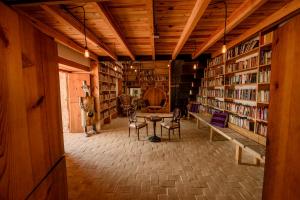 a library with a table and chairs and bookshelves at Ex Hacienda San José in Oaxaca City