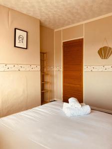 a bedroom with a white bed with a wooden door at 'Melrose' at stayBOOM in Lancaster