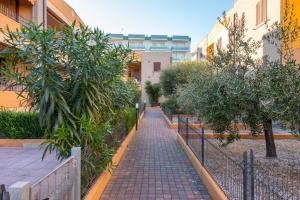 um caminho de tijolos num pátio com árvores e edifícios em Apartment with Terrace & Parking near the Sea em Marotta