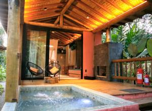 an outdoor swimming pool with a fireplace on a deck at Villa Manakás in Camburi