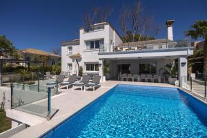 a villa with a swimming pool in front of a house at Villa La Perla by Finest Rentals in Marbella