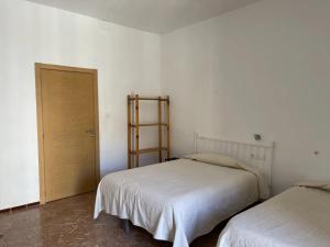 1 dormitorio con 2 camas y puerta de madera en Fonda Joan, en Santa Coloma de Farners