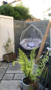 a swing with a bed on a patio with a plant at The Cottage, Ashfield Place in Bristol