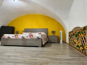 a bedroom with a bed and a yellow wall at Chimera House in Catania