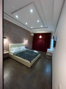 a bedroom with a large bed and a red wall at ГринПарк in Aktau