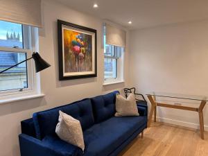 a living room with a blue couch and a table at Chapel - Central Studio Apartment in Bath