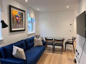 a living room with a blue couch and a table at Chapel - Central Studio Apartment in Bath +10 photos
