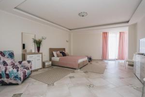 a bedroom with a bed and a couch and a chair at Villa Semiramis in Tivat
