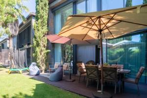 una terrazza in legno con tavolo e ombrellone di Home Six Troia a Carvalhal