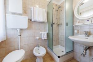 a bathroom with a toilet and a sink and a shower at Hotel San Rocco in Livigno +119 photos