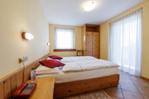 a bedroom with a large bed and a desk with a telephone at Hotel San Rocco in Livigno