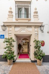 a building with a red rug in the doorway at Santacruz Hostal Plaza in Seville