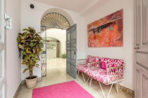 sala de estar con sofá rosa y alfombra rosa en Santacruz Hostal Plaza, en Sevilla