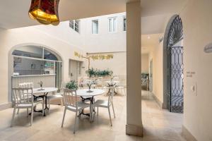 een eetkamer met tafels en stoelen en een gebouw bij Santacruz Hostal Plaza in Sevilla