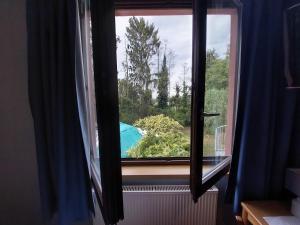 a window with a view of a swimming pool at Auberge De La Foret - Logis in Vendenheim