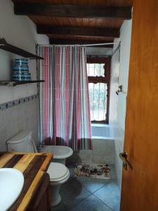 ein Badezimmer mit Toilette und Duschvorhang in der Unterkunft Casa del arroyo in Villa General Belgrano