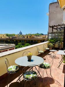 un patio con mesas y sillas en el balcón en Meraviglioso Attico con Terrazza Panoramica en Roma
