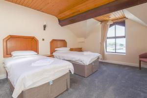 a bedroom with two beds and a window at Falcon's Nest Hotel in Port Erin