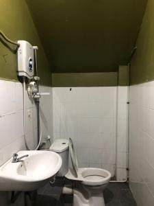 a bathroom with a toilet and a sink at MOTEL TERMINAL INN in Inanam