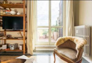 a living room with a chair and a large window at Meraviglioso Attico con Terrazza Panoramica in Rome