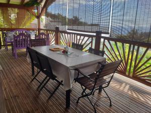 una mesa y sillas en una terraza de madera en Gîte 4 étoiles, la Vieille Sucrerie St Claude Guadeloupe, Jacuzzi Spa privatif, vue exceptionnelle sur la mer des Caraïbes, en Basse-Terre