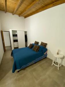 a bedroom with a blue bed and a table at Duplex nuevo Playa Unión in Playa Unión