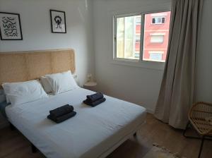 ein Schlafzimmer mit einem Bett mit zwei schwarzen Handtüchern darauf in der Unterkunft COOL! 5' to metro. 15' to Center/beach by metro. in Santa Coloma de Gramanet