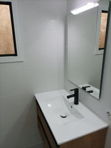ein Badezimmer mit einem weißen Waschbecken und einem Spiegel in der Unterkunft COOL! 5' to metro. 15' to Center/beach by metro. in Santa Coloma de Gramanet