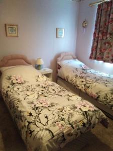 a bedroom with two beds with flowers on it at Weather Helm, 18 Highlands Road ,Andover in Andover