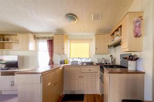 Kuchyň nebo kuchyňský kout v ubytování 8 Berth Caravan To Hire At Breydon Water Holiday Park In Norfolk Ref 10030b