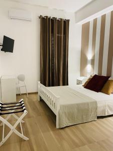 1 dormitorio con 1 cama blanca y 1 silla en La Titina Sella en Bari