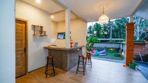 uma cozinha com um balcão e bancos num quarto em Aura Dormitory House Ubud em Ubud