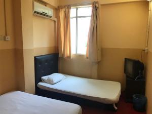 a room with two beds and a window and a television at MOTEL TERMINAL INN in Inanam