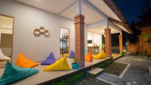 a group of colorful pillows on the porch of a house at Aura Dormitory House Ubud in Ubud
