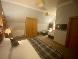 a hotel room with a bed and a tv at Ravelston House in Musselburgh