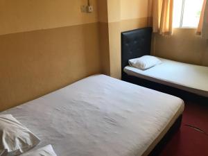 a room with two beds and a window at MOTEL TERMINAL INN in Inanam