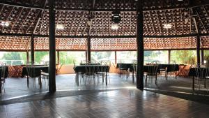 a room with tables and chairs in a building with windows at Itaygua Hotel in Ribeirão Preto