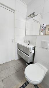 biała łazienka z toaletą i umywalką w obiekcie Beautiful luxury villa with private pool w Palm Beach