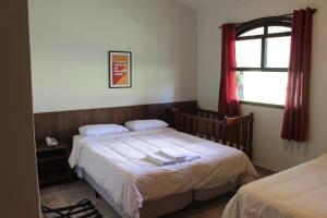 a bedroom with two beds and a window at Itaygua Hotel in Ribeirão Preto