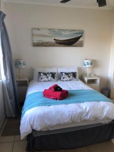 un cane che giace su un letto in una camera da letto di Sandpiper Cottage a Kleinemonde