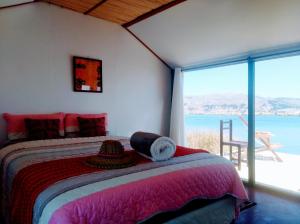 a bedroom with a bed with a view of the ocean at Titicaca wasy lodge in Puno