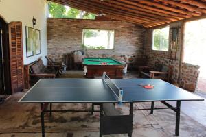 a ping pong table in a room with a pool table at Fazenda Itaygua Hotel in Ribeirão Preto