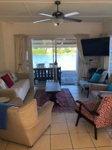 un soggiorno con un divano, sedie e un tavolo di Sandpiper Cottage a Kleinemonde