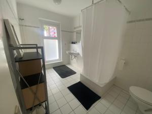 La salle de bains blanche est pourvue de toilettes et d'un lavabo. dans l'établissement Osthafen II, à Berlin